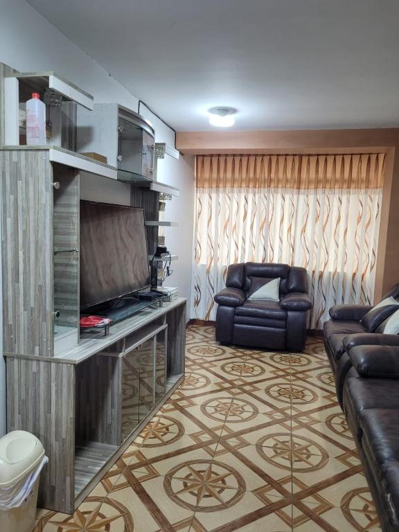 a living room with a couch and a television at Apartamento en Huancayo in Huancayo