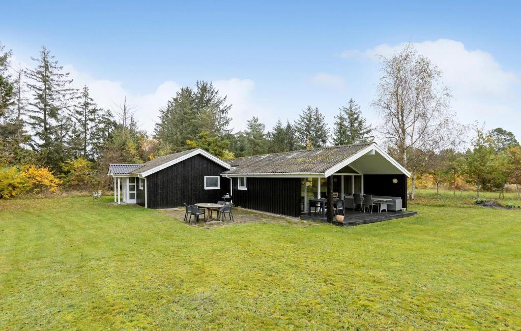 a black cabin with a grassy yard at 4 Bedroom Pet Friendly Home In Bindslev in Bindslev