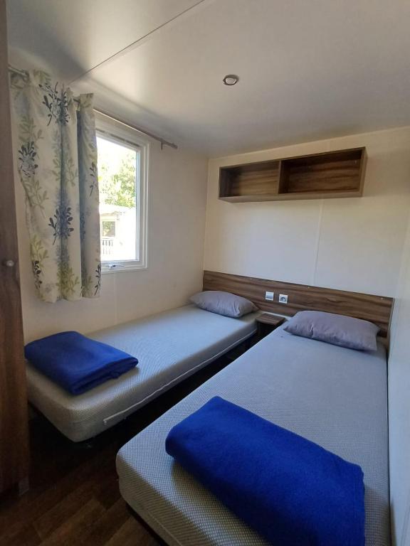 two beds in a small room with a window at Camping Tucan - Mobile Homes by Lifestyle Holidays in Lloret de Mar
