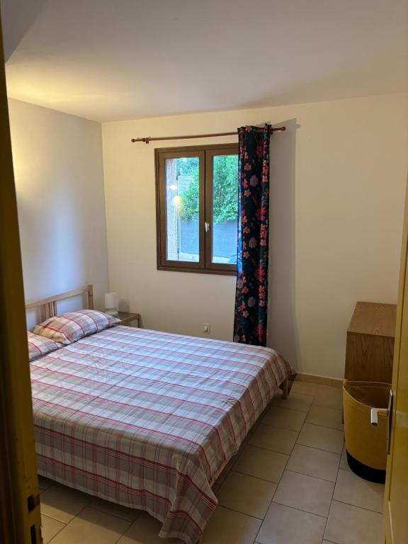 a bedroom with a bed and a window at Appartamento con giardino a 50 m dal mare in LʼÎle-Rousse