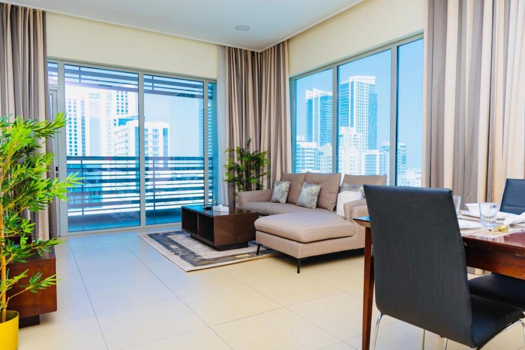 マナーマにあるAspire Tower - Two Bedroom Cowboy Themed Roomのソファとテーブルのあるリビングルーム