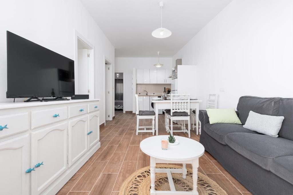 a living room with a couch and a table at Home2Book Cozy Beachfront Getaway in Tarajalejo in Tarajalejo