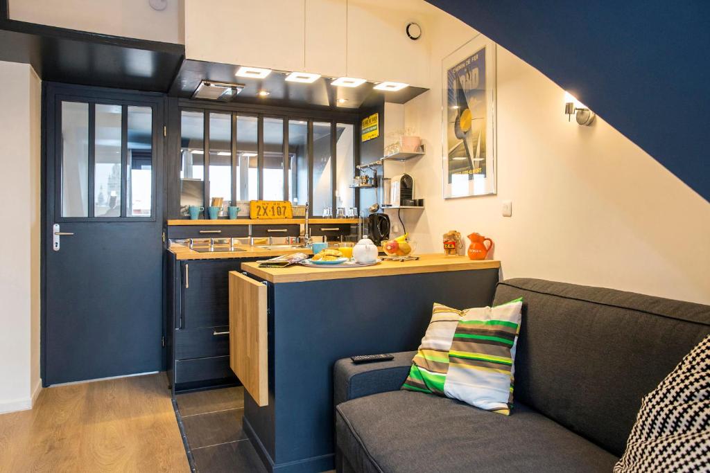 sala de estar con sofá y cocina en Little Suite - Marius et Romain en Lille