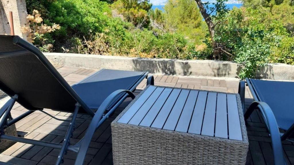 two chairs and a table and a blue table and chair at House Mare in Postira