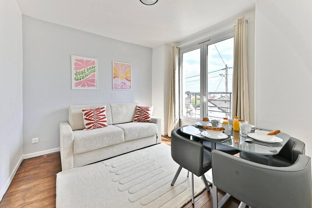 un salon avec une table et un canapé dans l'établissement Séjour paisible 4 personnes Banlieue Parisienne-II, à Gagny