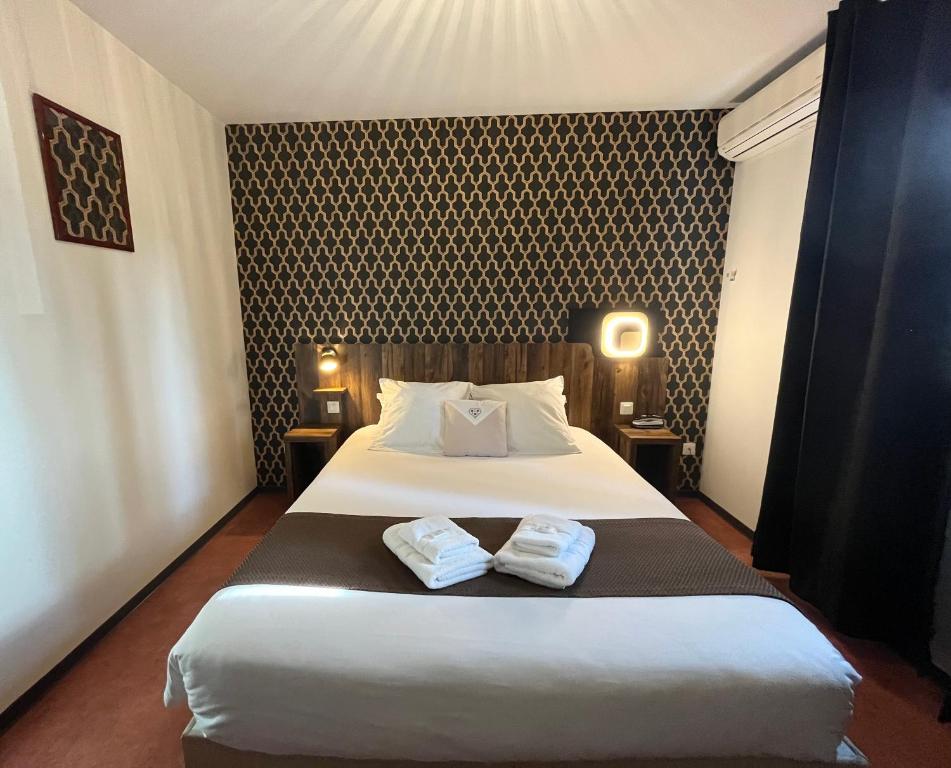 Un dormitorio con una cama con dos toallas encima. en FastHôtel Mont de Marsan - Un Hôtel FH Collection, en Mont-de-Marsan