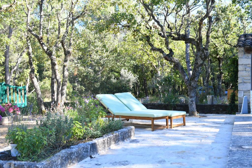un banc assis sur un trottoir dans un parc dans l'établissement La Piscine dans la Foret, à Gordes