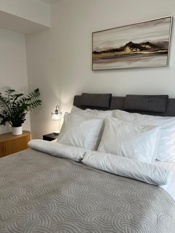 a bed with white pillows and a picture on the wall at Riverside Apartment in Tartu