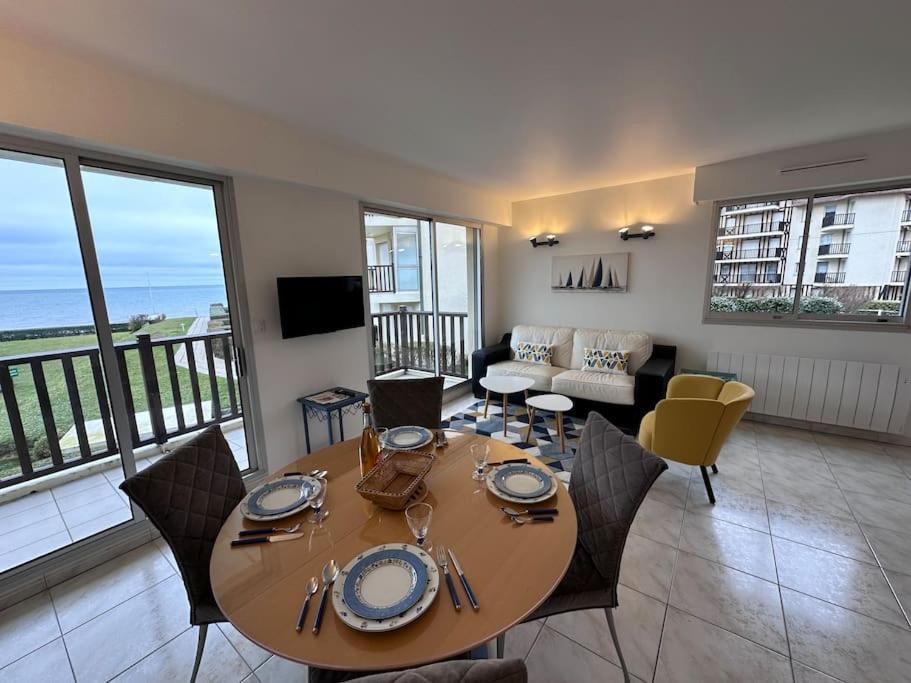 une table à manger et des chaises dans un salon dans l'établissement Entre Dunes et mer - Accès privé à la mer, à Cabourg