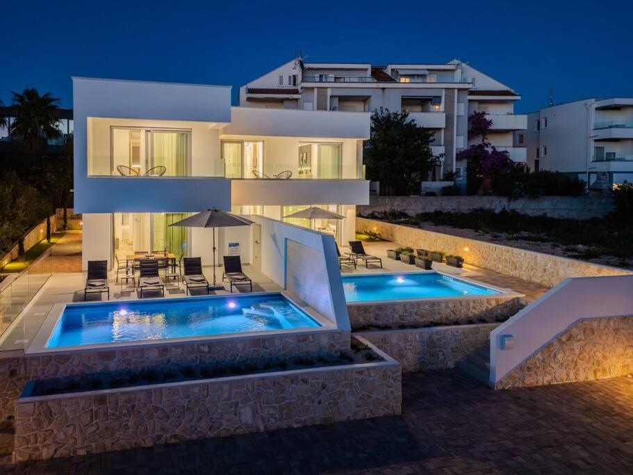 a villa with a swimming pool in front of a building at Villa Nova Excellence 1, villa with private pool in Novalja