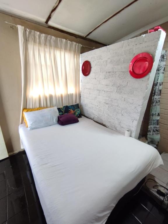 a large white bed in a room with a brick wall at 26 molen street in Rustenburg