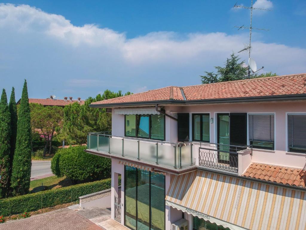 Casa con balcón y árboles en Appartamenti America, en Sirmione