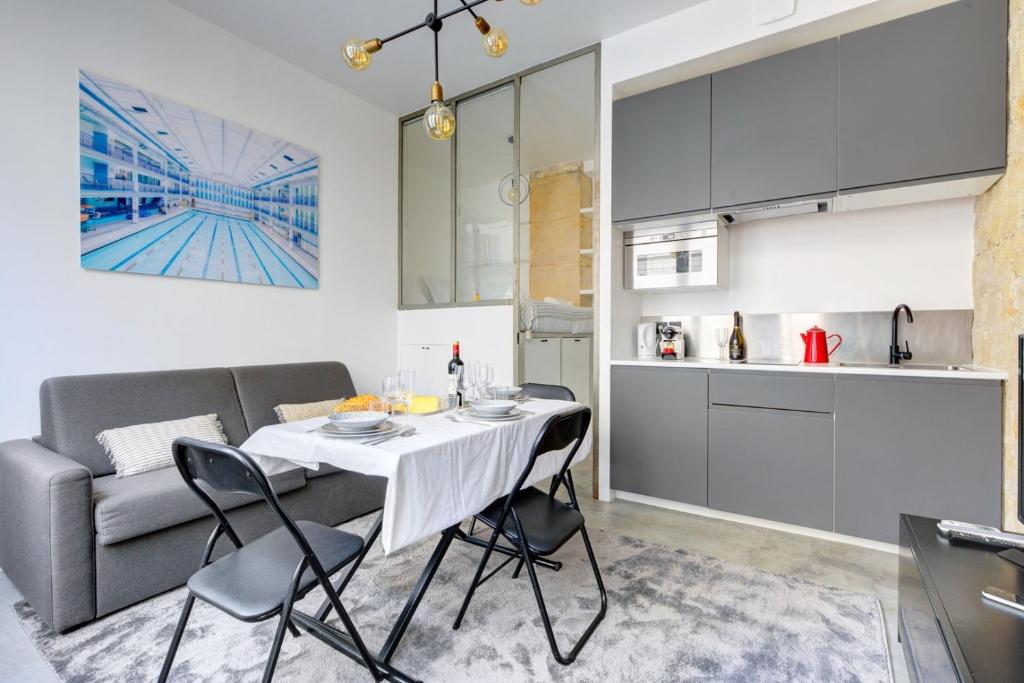 une cuisine et un salon avec une table et un canapé dans l'établissement Bluestay 150 - Charmant appartement à Paris, à Paris