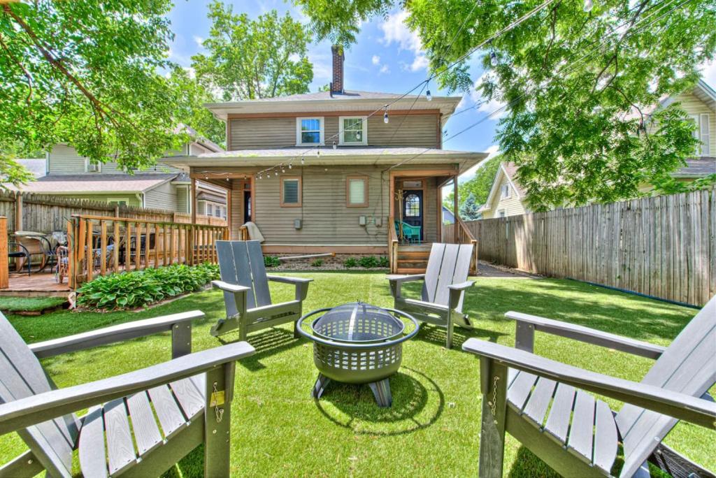 a yard with chairs and a table and a house at 6 Bedroom Duplex Sleeps 14 Close to Lucas Downtown in Indianapolis