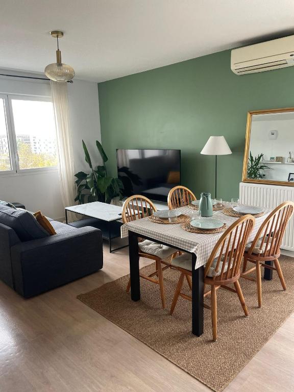 un salon avec une table, des chaises et un canapé dans l'établissement Appartement 3 chambres, Terrasse, Parking, Clim', à Bordeaux