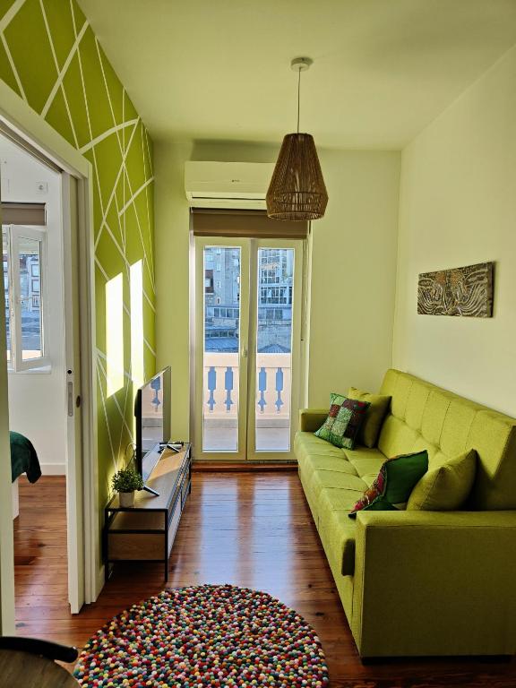 a living room with a green couch and a rug at Apartamentos Principe in Vigo