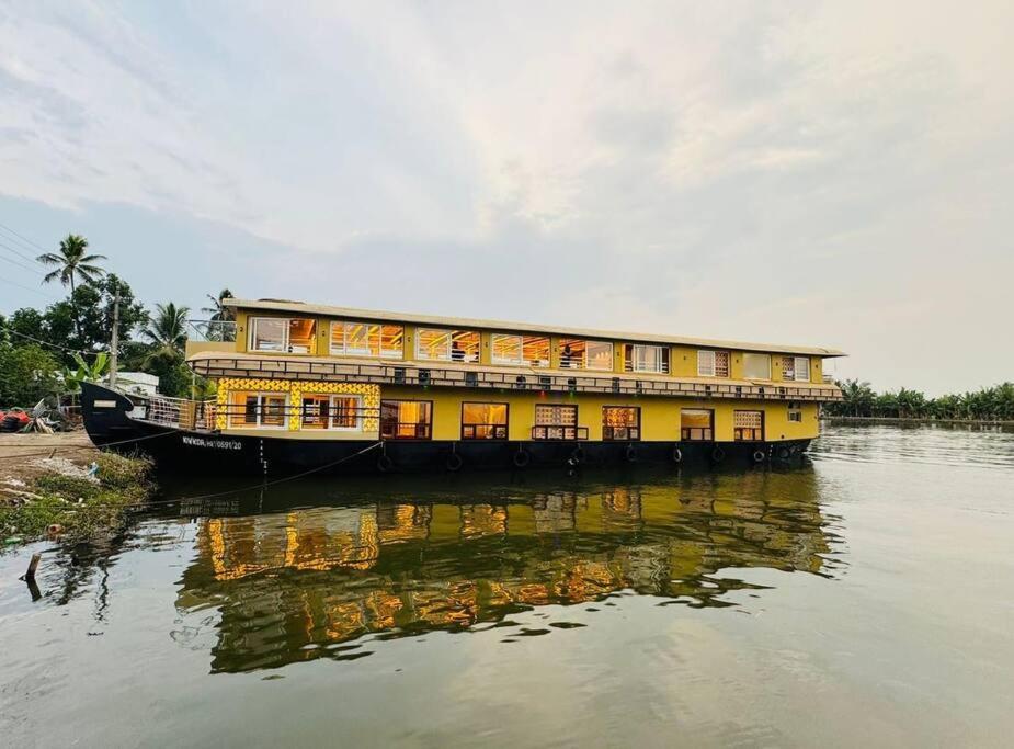 アレッピーにあるDream Luxury Houseboat Awaits !の川船黄色の建物