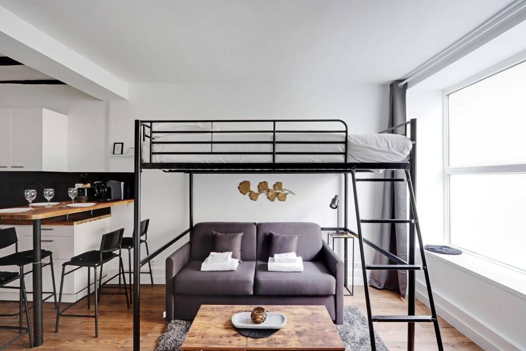 Cette chambre comprend une mezzanine avec un canapé et une table. dans l'établissement Butte Aux Cailles Charming Studio 4P, à Paris