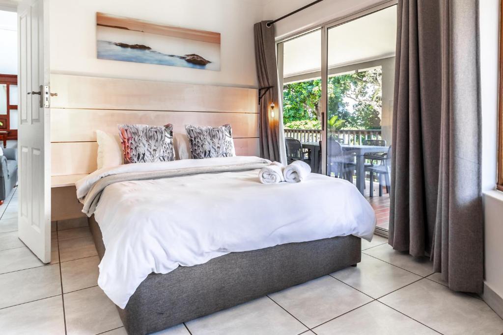 a bedroom with a large bed and a balcony at The Bridge Unit 8 in St Lucia