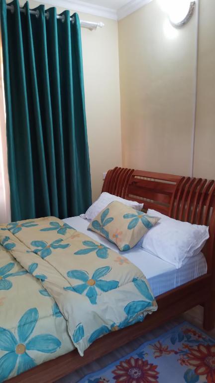 a bedroom with a bed with a green curtain at CoolHome at Mbezi Beach in Dar es Salaam