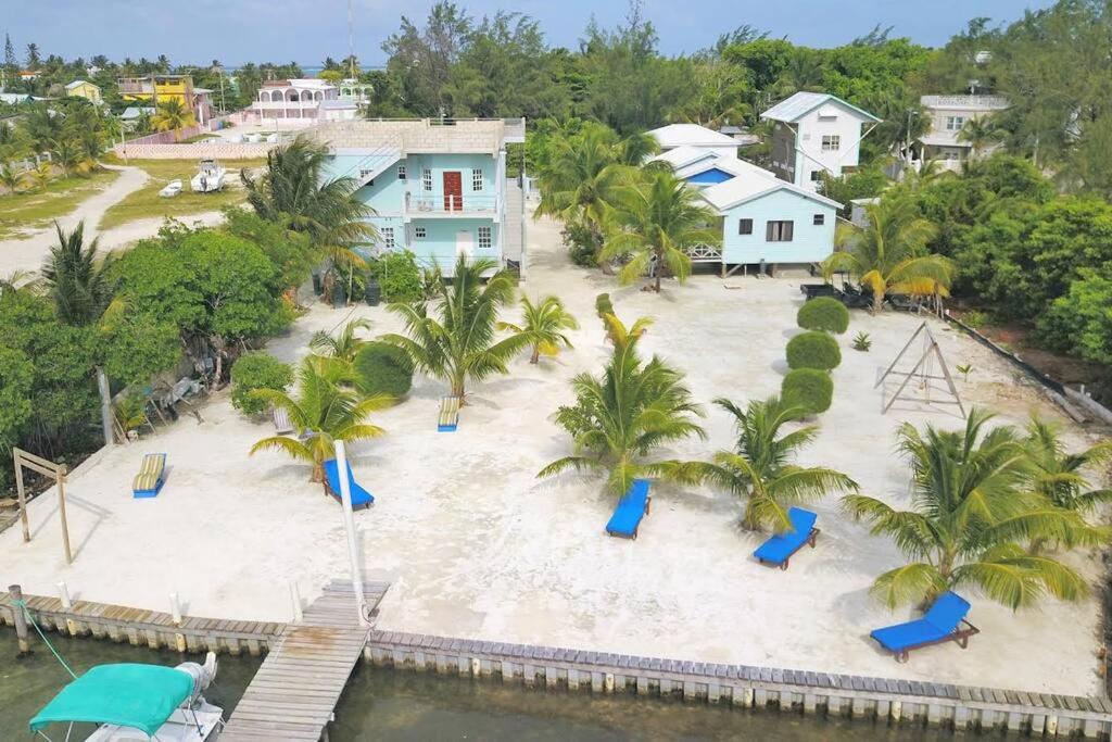 einen Luftblick auf einen Strand mit Palmen und blauen Rutschen in der Unterkunft Hidden Treasure Vacation Home Lagoona bay cottage in Caye Caulker