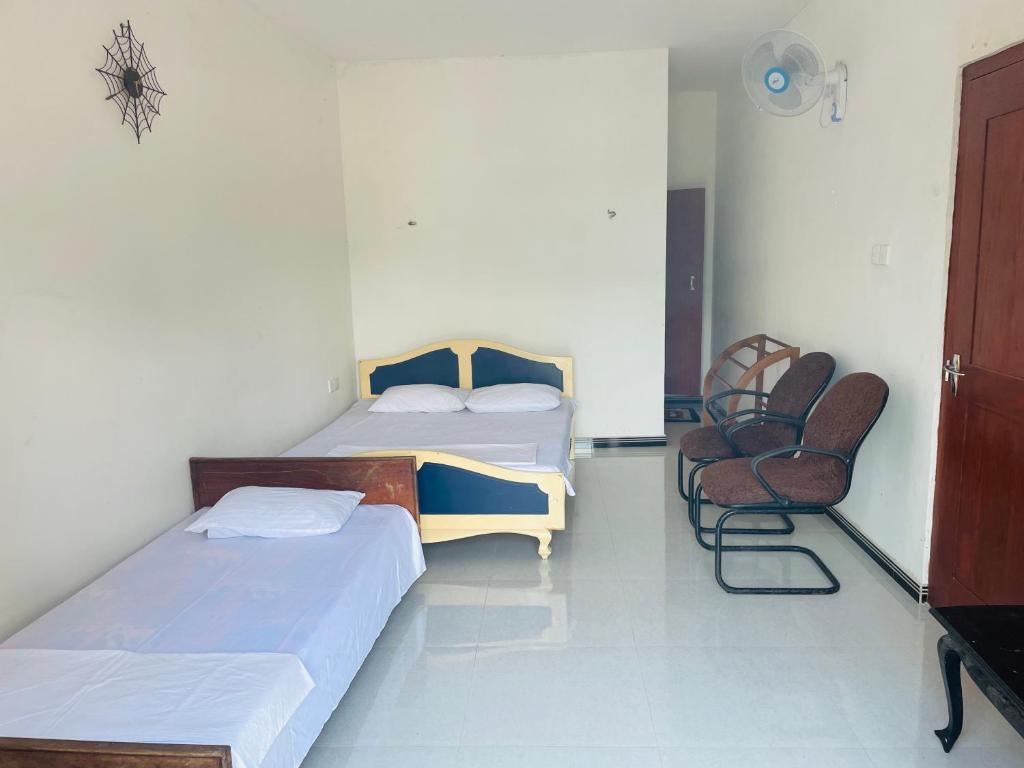 a room with two beds and a chair in it at Dream Holiday Home Badulla in Badulla