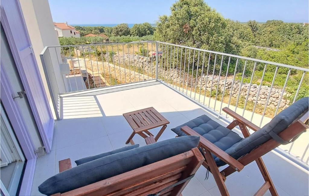 奥利布岛2 Bedroom Gorgeous Apartment In Olib的带两把椅子和一张桌子的阳台