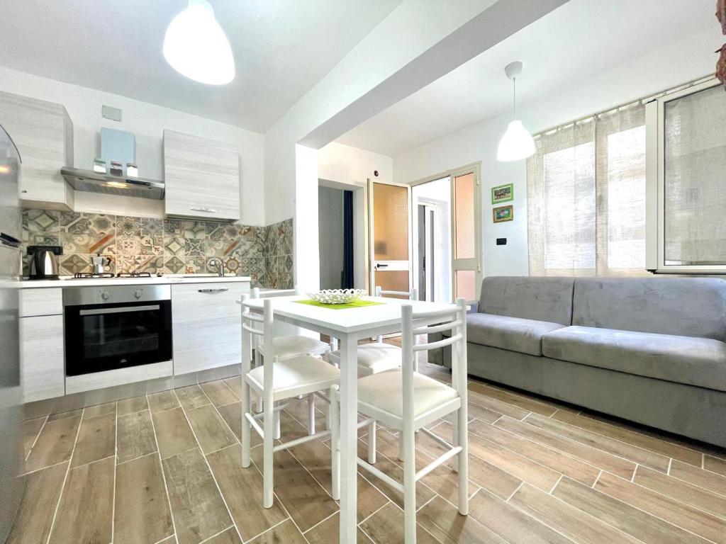a kitchen and living room with a white table and chairs at Teddy House Apartments in Bari Sardo