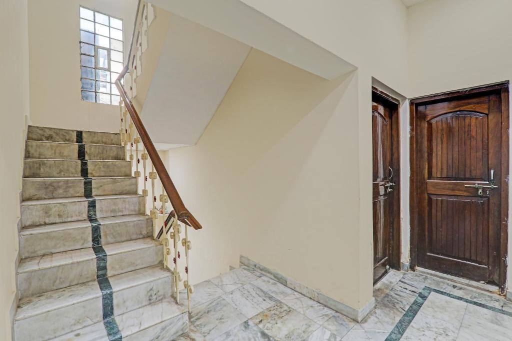 a staircase in a house with a wooden door at Hotel O PG ON GANGES in Rāmnagar