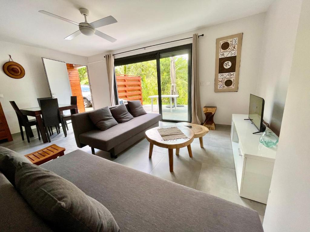 un salon avec un canapé et une table dans l'établissement Kaza Jolan à Sainte Anne, à Sainte-Anne