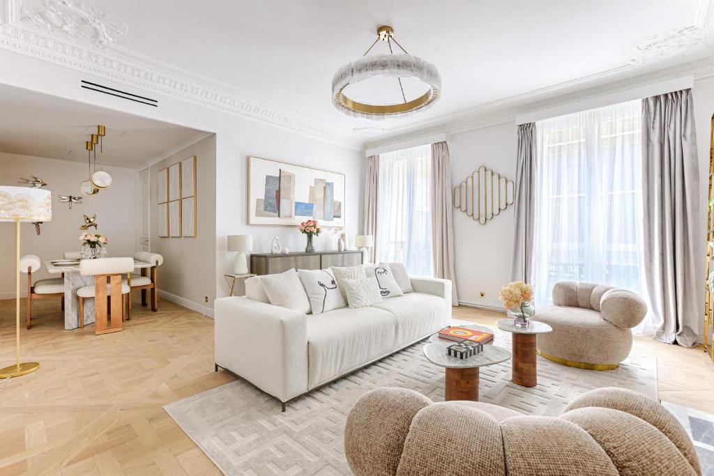un salon avec un canapé blanc et une table dans l'établissement Elegant Luxury Apartment for 6 on Champs-Élysées, à Paris