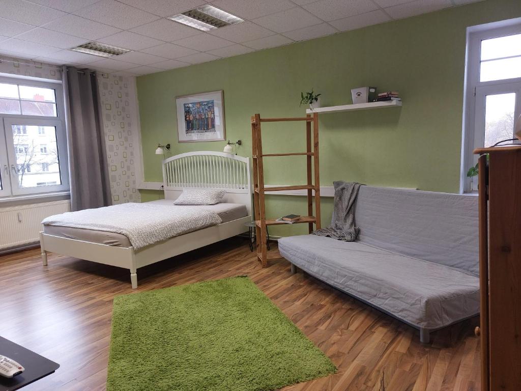 a bedroom with two beds and a green wall at Salon Till in Magdeburg