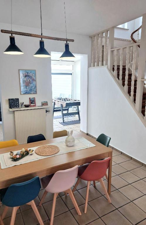 une salle à manger avec une table et des chaises en bois dans l'établissement Magnifique Malouine 10 personnes, à Dunkerque