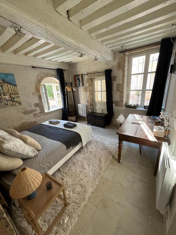 a bedroom with a large bed and a wooden table at L'Atelier d'Olga - Homillesime in Dijon
