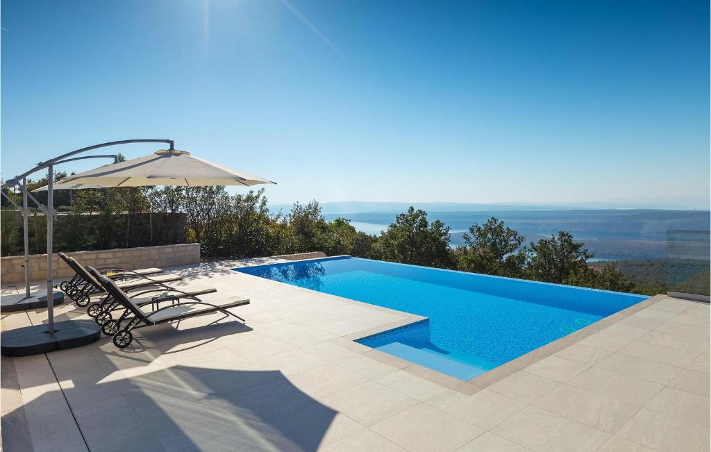 GrmaniにあるVilla Infinityのスイミングプール(隣にパラソルと椅子付)