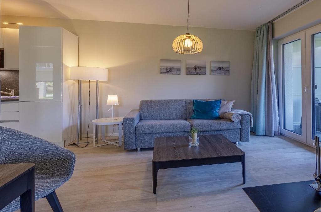 a living room with a couch and a table at 5 Sterne Ferienwohnung Große Strandburg - Wellnessurlaub zwischen Ostsee und Bodden in Wustrow