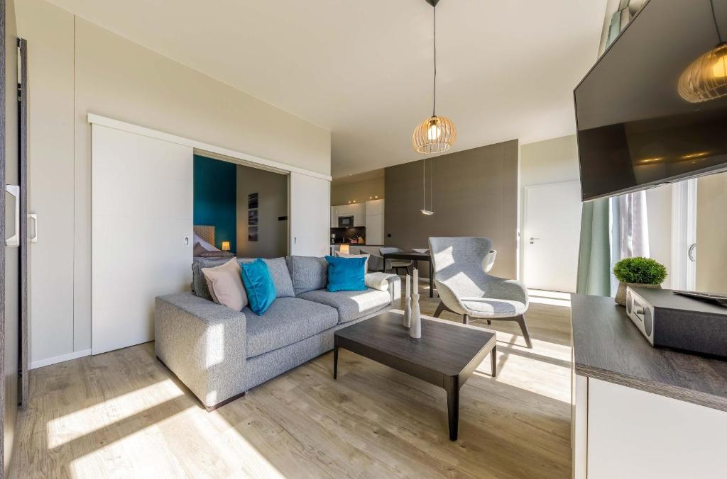 a living room with a couch and a table at Ostsee-Schönheit Wustrower Welle-Modernes 2-Zimmer-Apartment mit Panoramablick in Wustrow