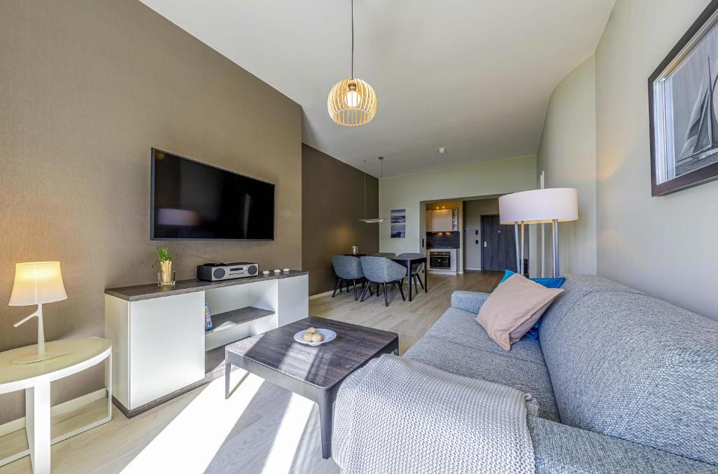 a living room with a couch and a tv at Seerose 5-Sterne-Ferienwohnung Erholung zwischen Ostsee und Bodden in Wustrow