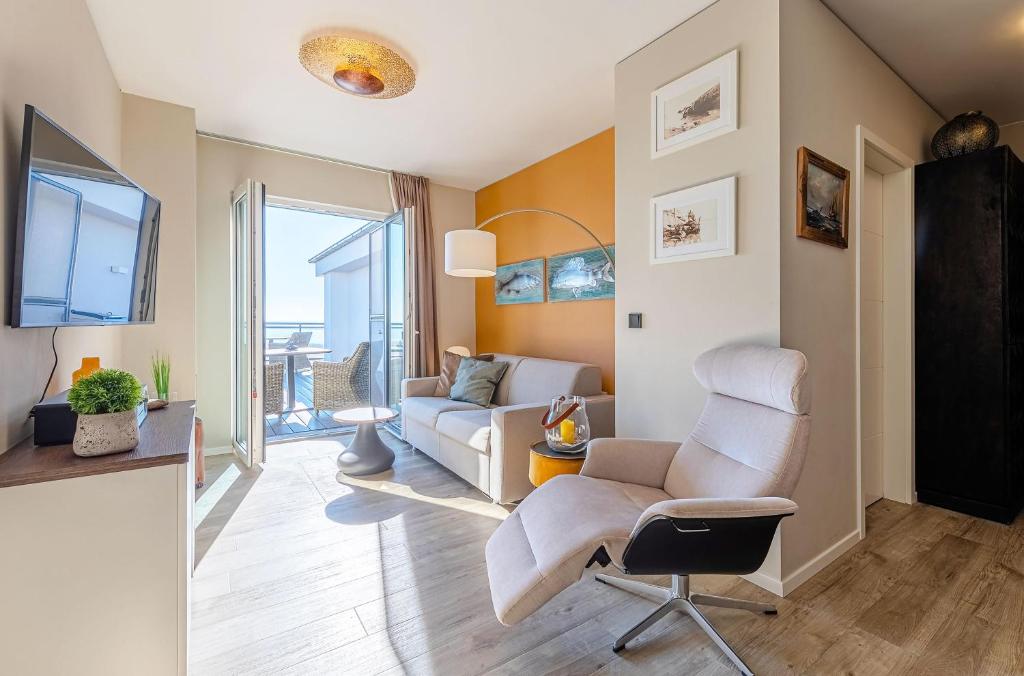 a living room with a couch and a chair at Sommertraum - Charmante 3-Zimmer Wohnung mit Eckbalkon in Wustrow in Wustrow