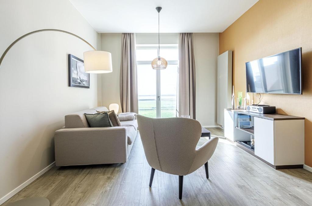 a living room with a couch and a chair at Ostseeglück - 5-Sterne-Ferienwohnung mit Südbalkon und Blick zum Saaler Bodden in Wustrow