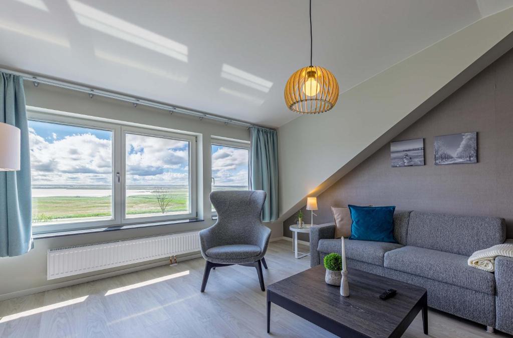 a living room with a couch and a chair at Seebadperle - 5 Sterne Ferienwohnung - Exklusives Ambiente zwischen Ostsee und Bodden in Wustrow