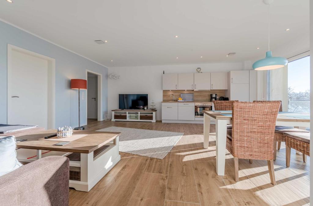 Una sala de estar con una mesa y una cocina. en Wasserlilie - Stilvolle Ferienwohnung mit Balkon und herzlich willkommenen Vierbeinern, en Malchow