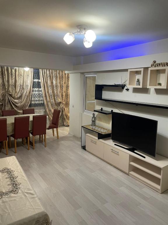 a living room with a television and a dining room at Strada calea unirii bloc 5 in Craiova