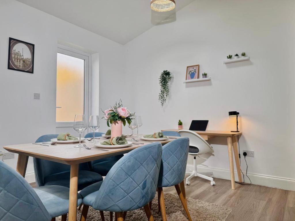 Hotel Cosy 1-Bed Flat 30min to Central London & Parking, a dining room with a table and blue chairs at Cosy 1-Bed Flat 30min to Central London & Parking in London