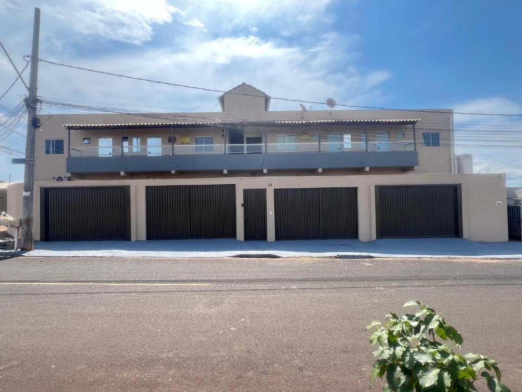 a large house with a fence and a building at Loft Familiar BR-Aeroporto 4 in Uberlândia