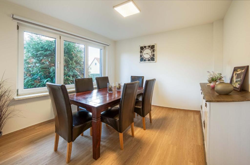 ein Esszimmer mit einem Holztisch und schwarzen Stühlen in der Unterkunft Ferienhaus Casa Castagno mit Garten, Balkon und Sauna- heißt Sie herzlich willkommen! in Alt Schwerin