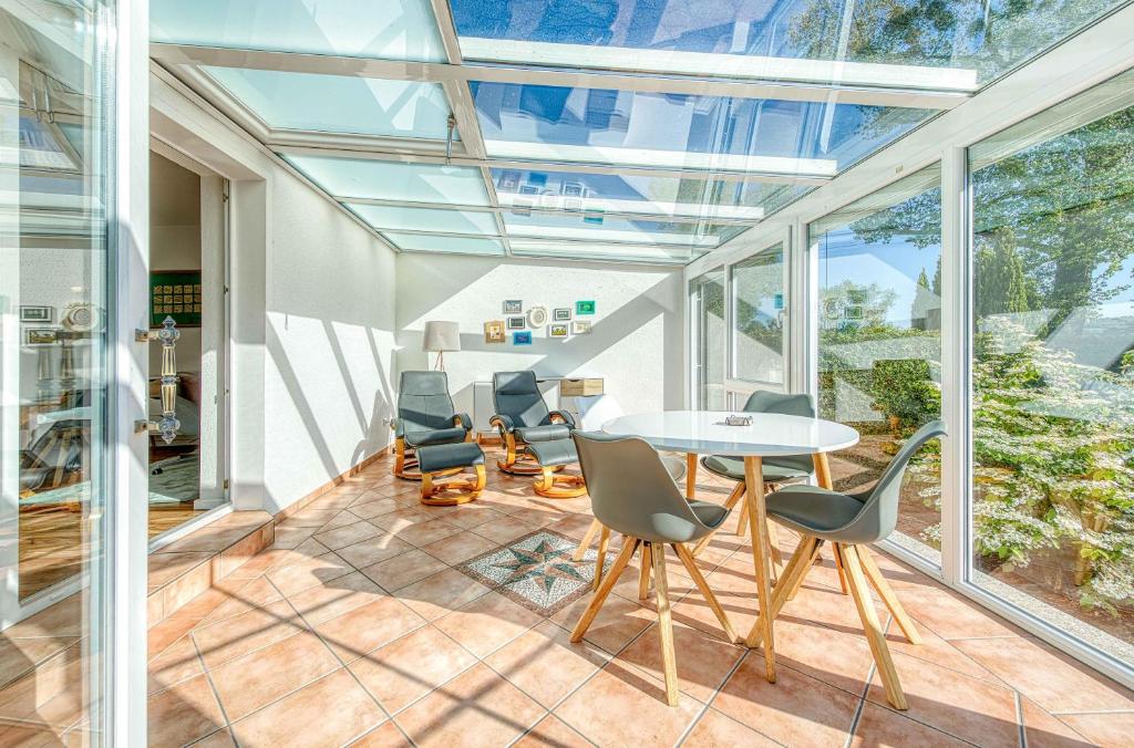 a room with glass ceilings and a table and chairs at Ferienhaus Eddi am Tiefwarensee in Waren