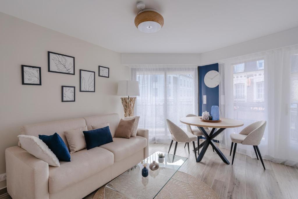 a living room with a couch and a table at Central appartement with terrace and free parking in Deauville