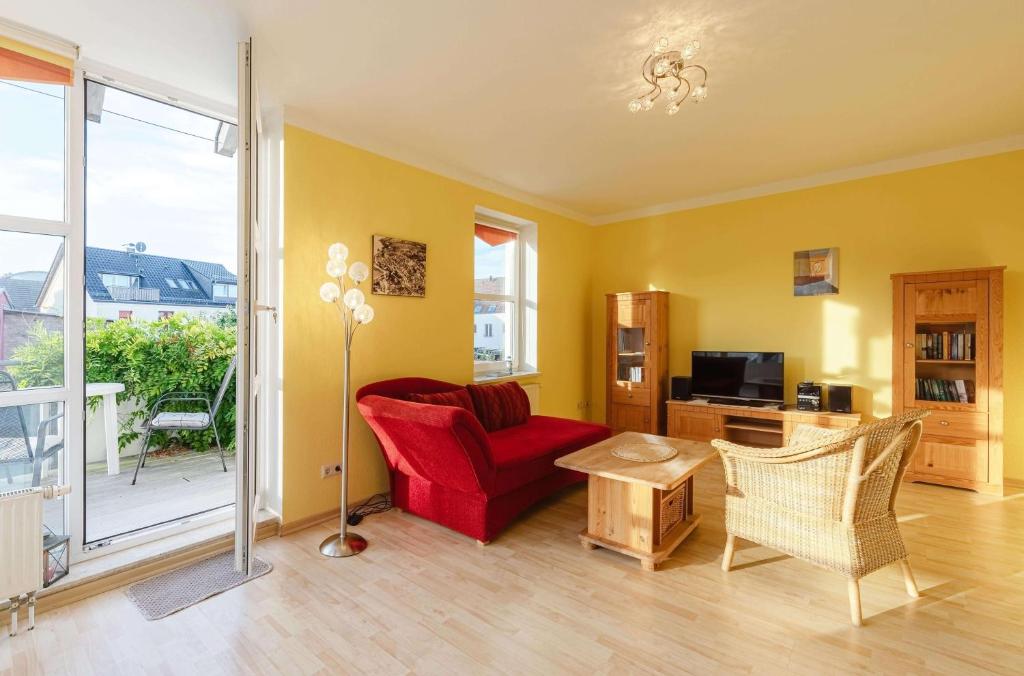 a living room with a red chair and a table at Hafenoase mit Eckbalkon in Waren
