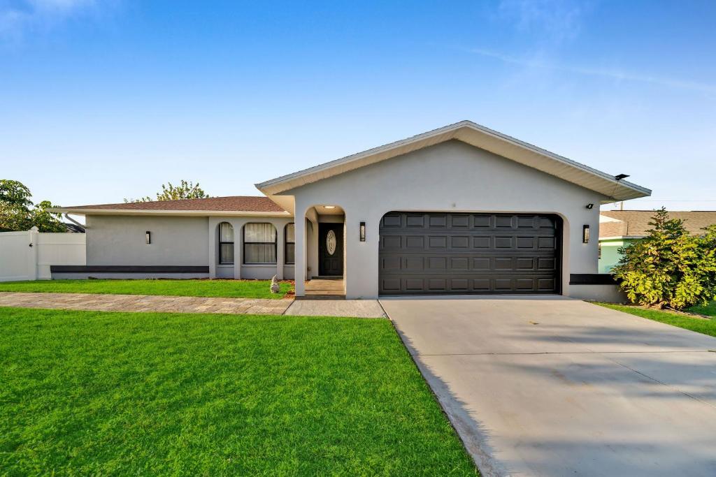 una grande casa bianca con garage di House With Pool a Cape Coral